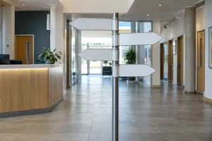 Blank directional arrows stand in an empty public service lobby beside a quiet reception counter.