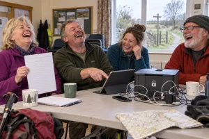 Four fictional adult sports club members laughing around a tablet, paper sign up sheet and locked printer before a community walk.