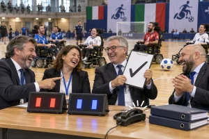 Four fictional adult administrators clearly laugh beside abstract scoreboards at a powerchair football court.