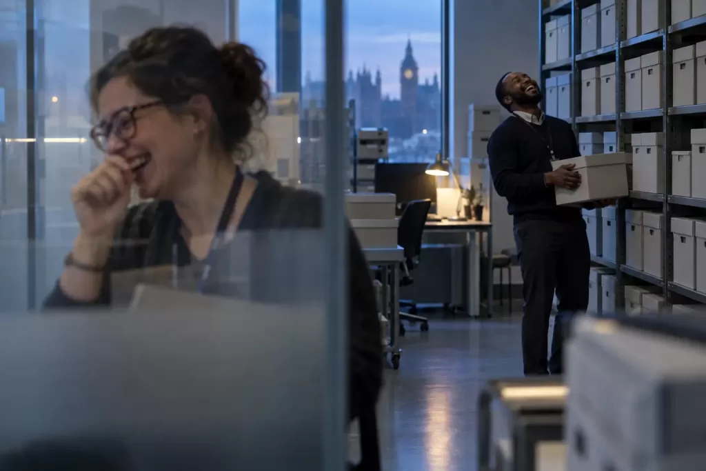 Two laughing data stewards at a fictional government data asset management policy 2026 archive