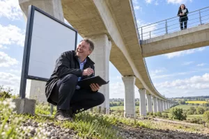Two laughing railway planners at fictional HS2 project reset 2026 viaduct
