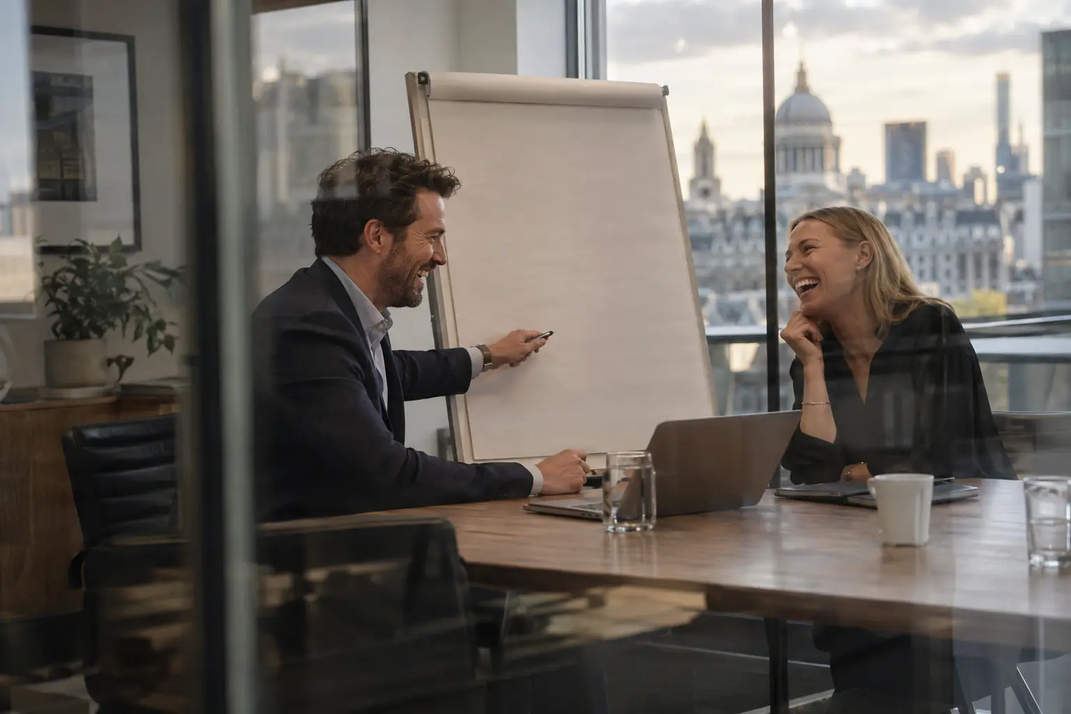 Two laughing consultants in a fictional Professional and Business Services Council co-chair 2026 meeting